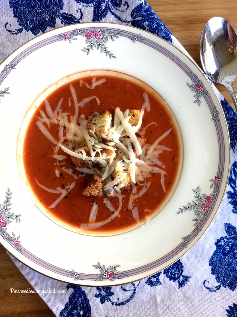 10 minute tomato soup in a bowl topped with croutons and cheese.